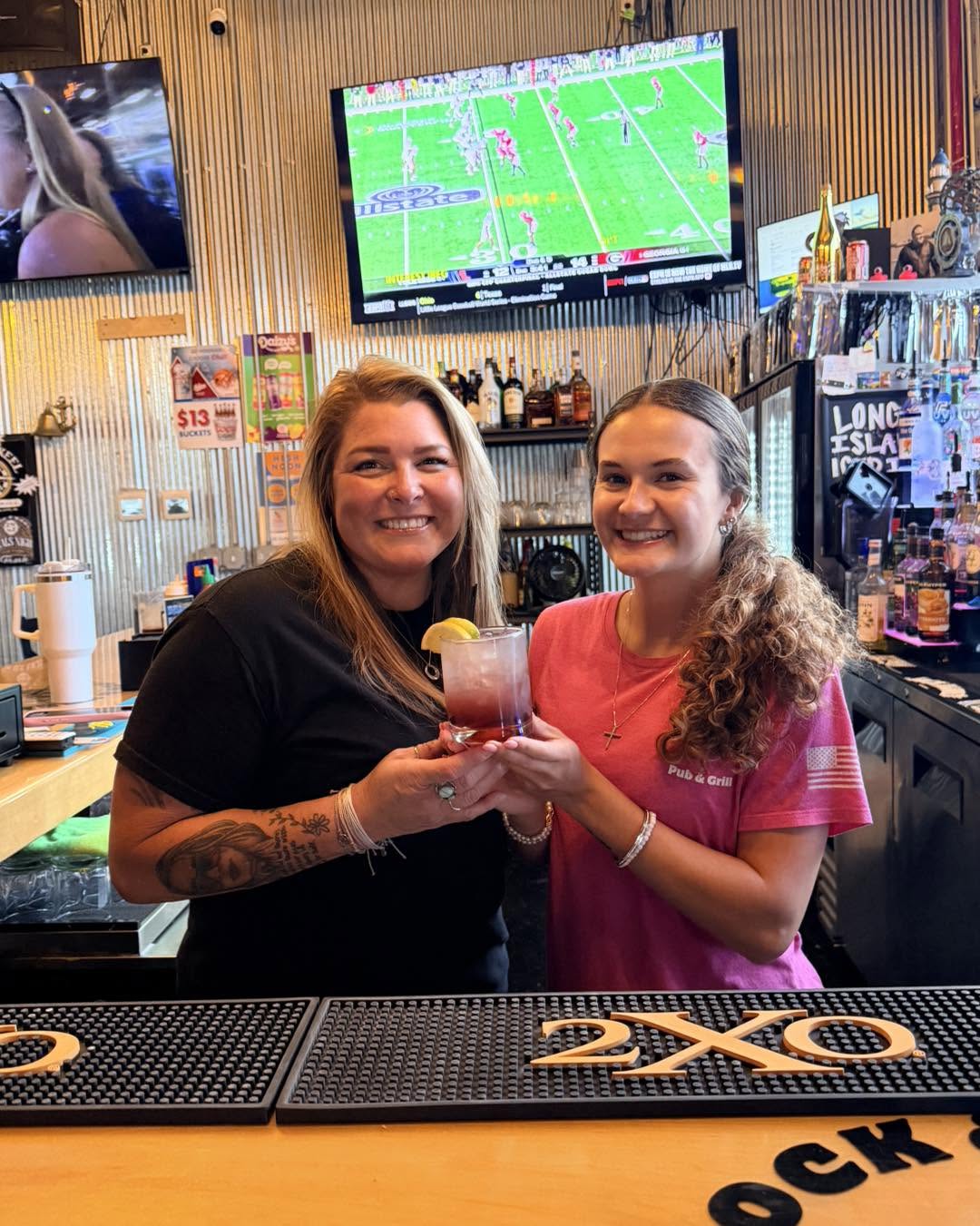 Two people holding a cocktail together behind the Lock & Keel bar, from the business Facebook page