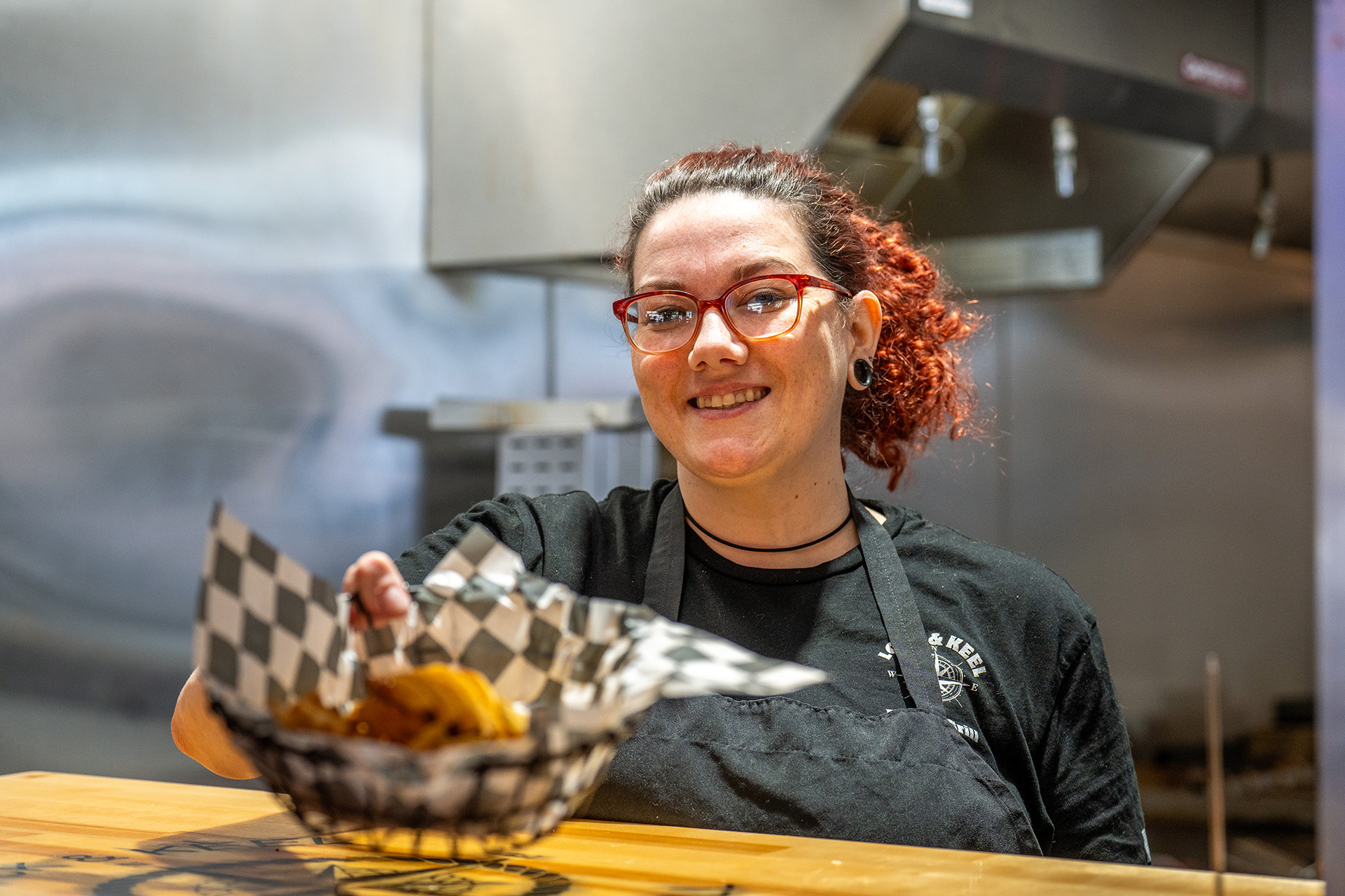 A smiling Lock & Keel team member serving food